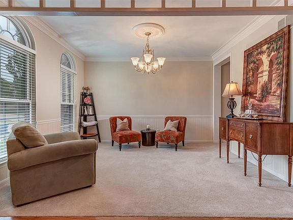 Dining room located off foyer (currently used as a sitting room) has wonderful arched windows, triple crown molding and chair rail