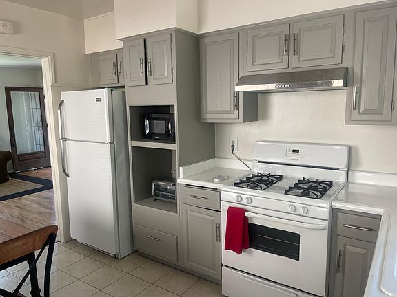 kitchen w/ fridge, stove, microwave, toaster oven, dishes, glassware and utensils