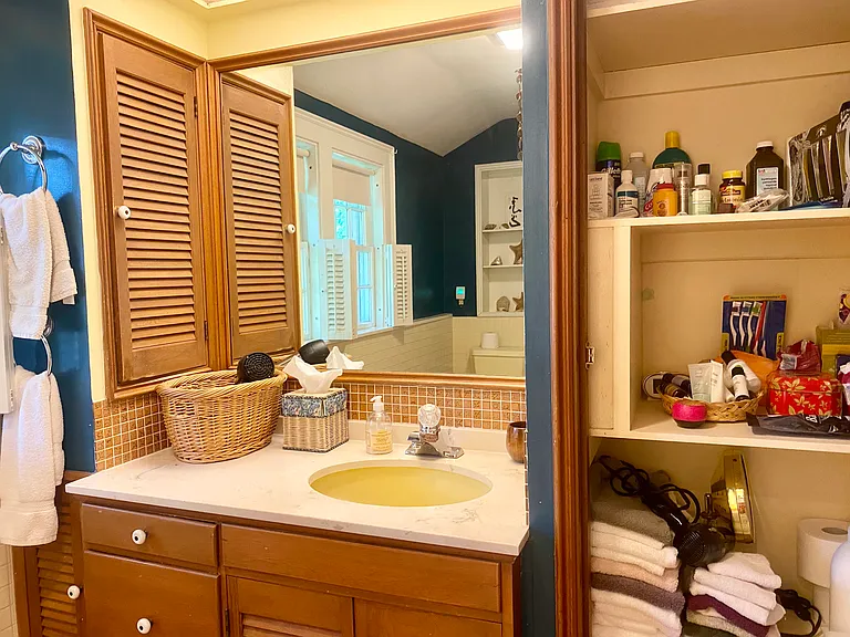 The bathroom has a large closet, and side closet above the sink, plus a cupboard and drawers