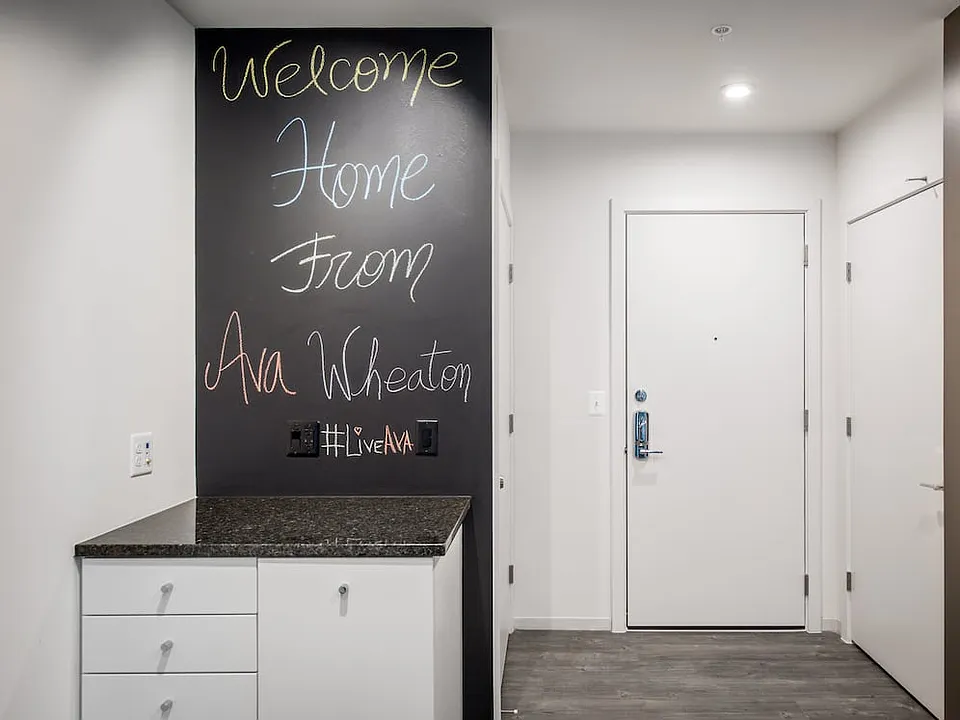 Apartment entry with hard surface flooring and chalkboard wall