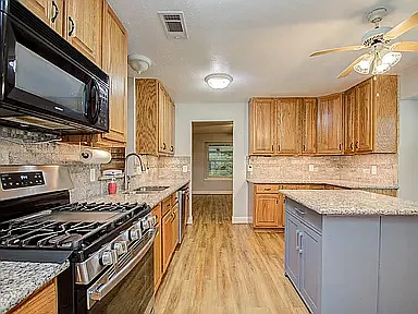 Updated kitchen featuring granite countertops, ample cabinet space, and modern appliances.