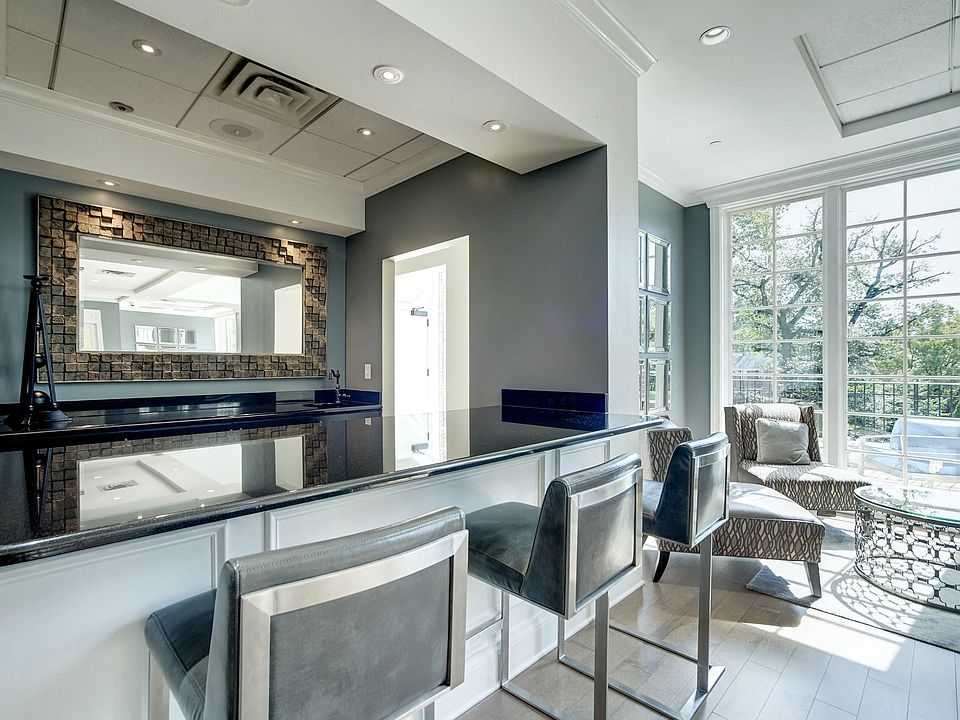 Expansive Resident Clubhouse with Plush Seating Areas, Cozy Fireplace, Balcony Area, and Bar