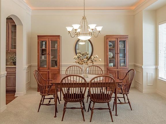 formal dining room with crown molding with rope lighting and chair rail molding