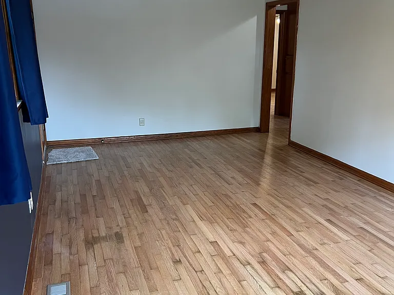 Living room showing exterior door on left and connection to the hallway