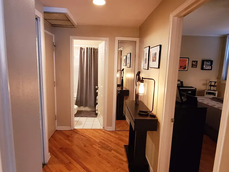 Fyer looking into the bedroom and bathroom, full length mirrors on linen and coat closet doors.