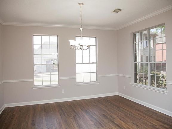 Formal dining room has received an updated lighting fixture, fresh paint on walls and trim. To the left of this photo is the kitchen.