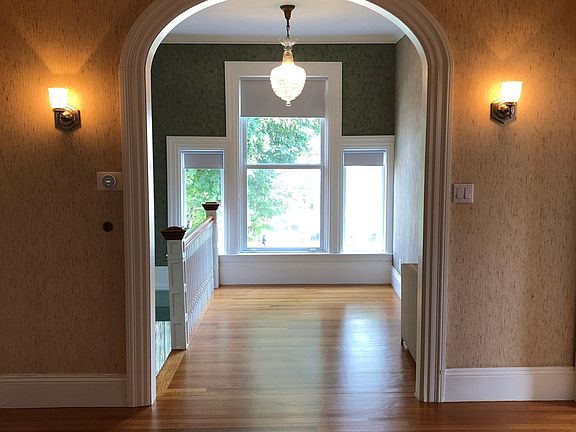 View from Reception Hall/Office space to the front hall space. Antique crystal chandelier.