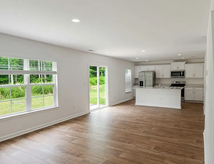 Open-concept living / dining area looking into the kitchen
Spacious open-concept main living area with soaring ceilings, recessed lighting, and large multi-pane windows that flood the space with natural light.