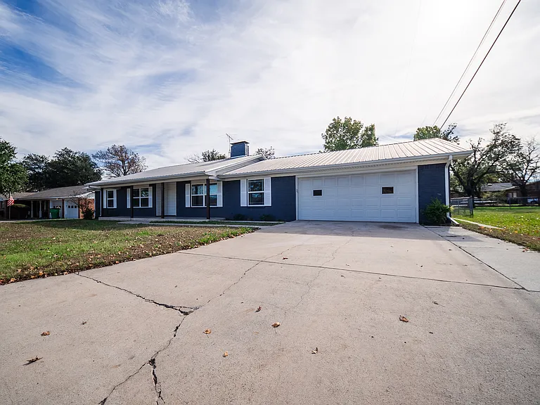 Elevated view of the front exterior with driveway and blue siding