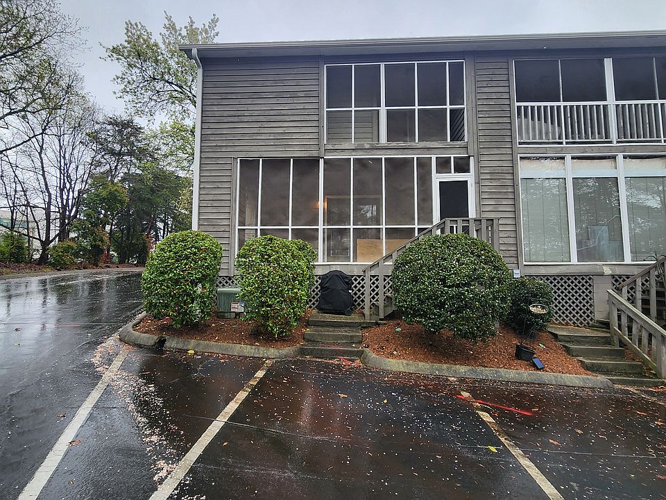 Back of home view of both levels of the screened in porches and parking.