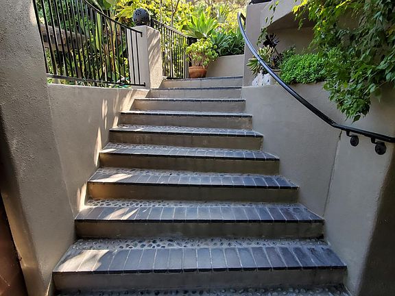View of the steps to front door from covered parking spaces