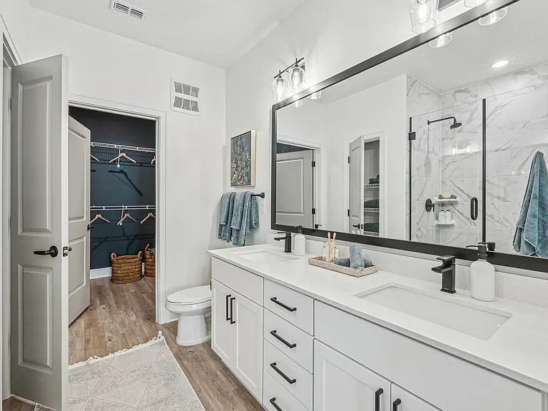 Bathroom with Quartz Countertops, Double Vanity Sinks, Walk-in Shower, and Walk-in Closet