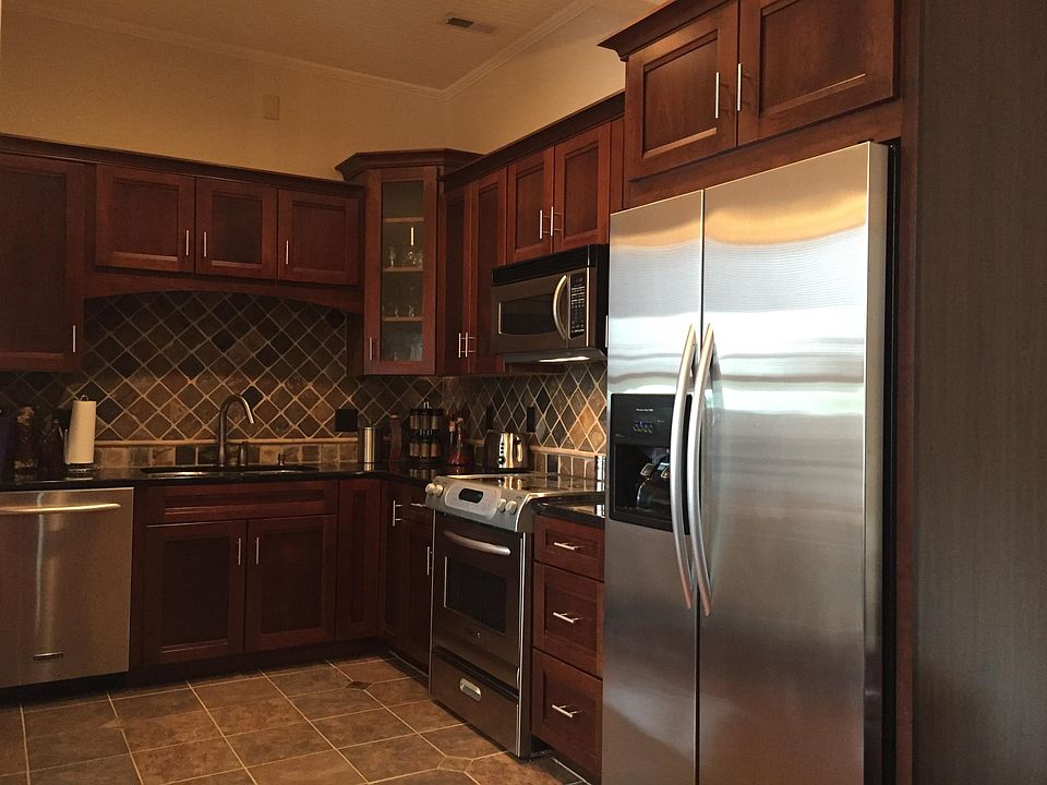 The kitchen features stainless appliances, garbage disposal, natural granite countertops, slate backsplash and an eat at bar suitable for two (not pictured).