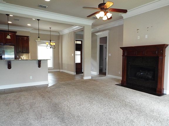 Comfortable carpeted living room area with gas fireplace and gorgeous moulding in each room.
