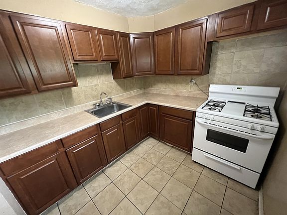 Kitchen with ceramic tile floor and gas range.
