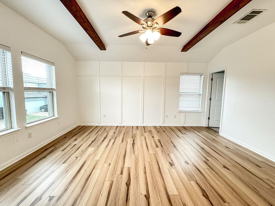Master Bedroom- LVP Flooring, Wooden Beams, Ceiling Fan and ample Natural Light