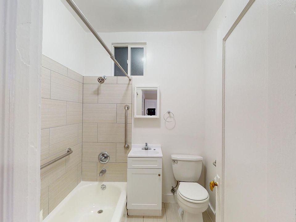 Bathroom with bathtub, tiled shower, vanity, sink, toilet, mirrored cabinet