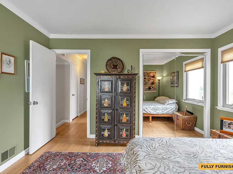 Second bedroom on the main level is furnished with a queen bed, desk and chair, large closet with sliding mirrored doors, dresser and floor lamp and has two windows and a corner desk with desk chair.