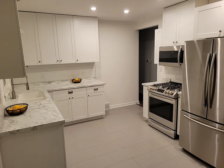 kitchen view of stove, microwave and refrigerator.