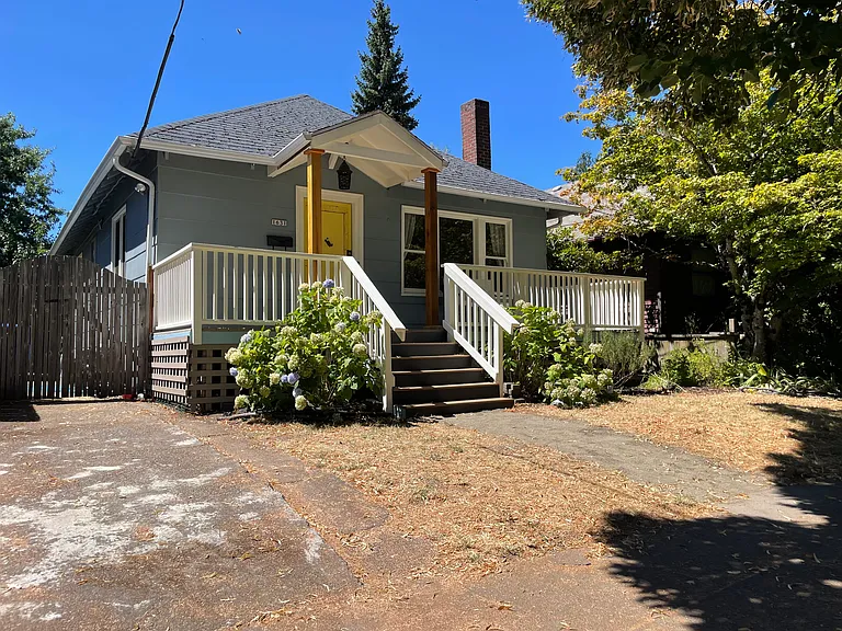 Front of house, driveway on the left.