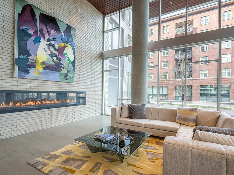 Fireplace inside a large feature wall with artwork hanging above