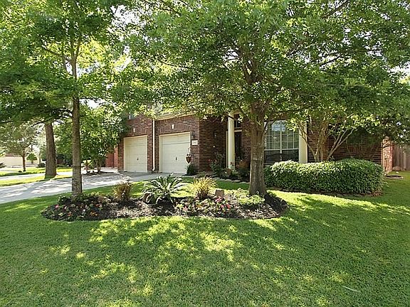 Trees and professional landscape enhance the architectural elevation of this brick veneer & cement board low maintenance home.