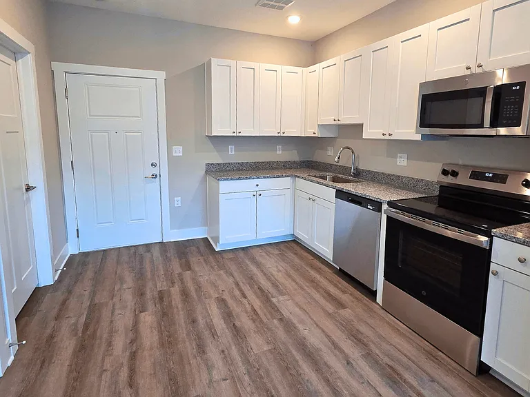 Kitchen and living area of an available apartment unit at Greenwood Commons Apartments in Delaware, OH.