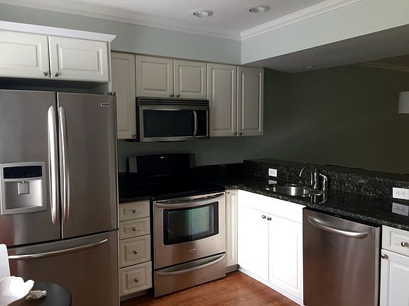 Kitchen with granite, stainless appliances, and white cabine