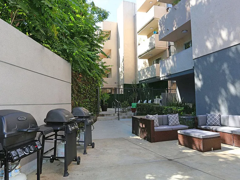 Courtyard view of community seating area next to barbecues.