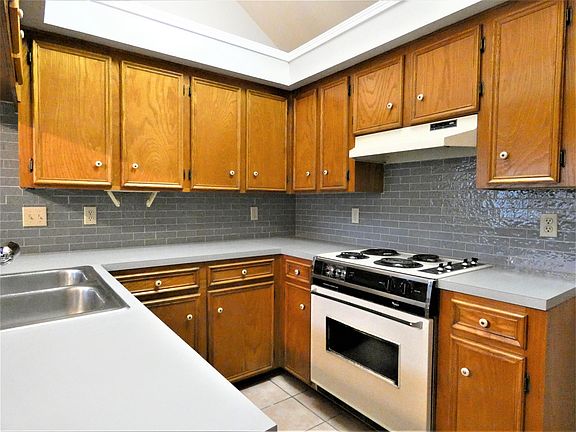 Kitchen area has new counter tops with glass subway tile backsplash.