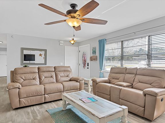 First of two living rooms with 2 reclining leather sofas and smart TV.