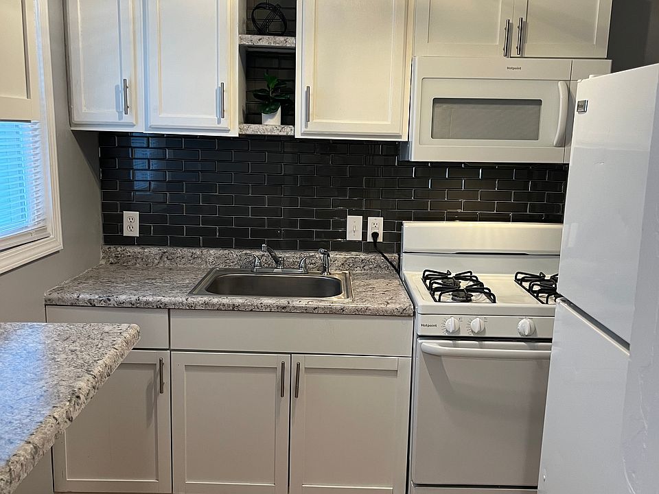newly renovated kitchen with luxury gray glass block style back splash! and microwave/vent combo over stove.