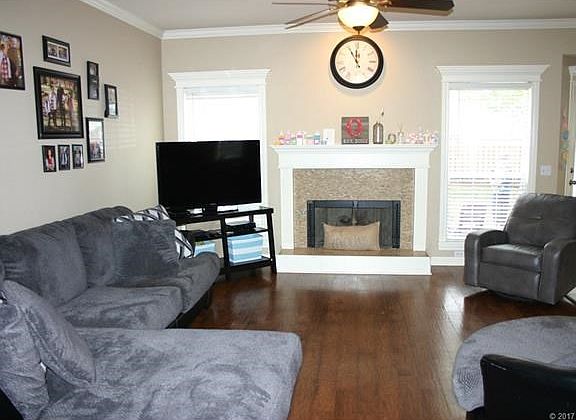 Large living room with high ceilings, wood floors, crown molding and beautiful gas fireplace.
