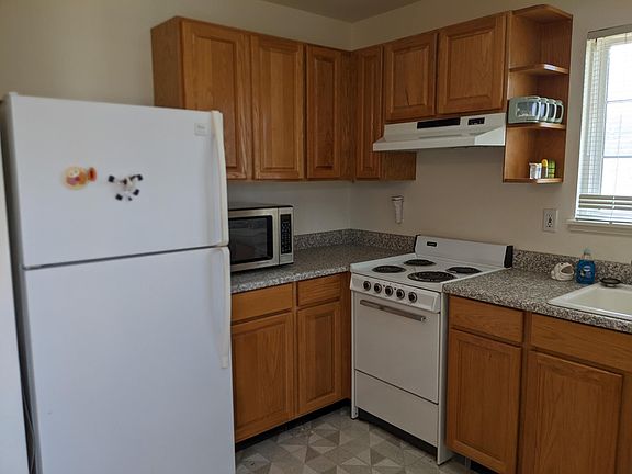 Kitchen with electric stove, microwave, refrigerator and freezer