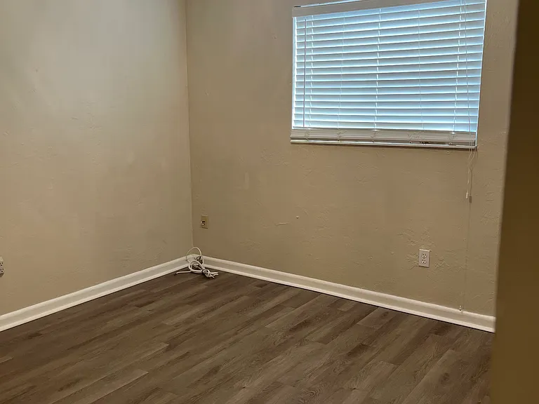 First bedroom on the left side of the hallway, across from the bathroom.