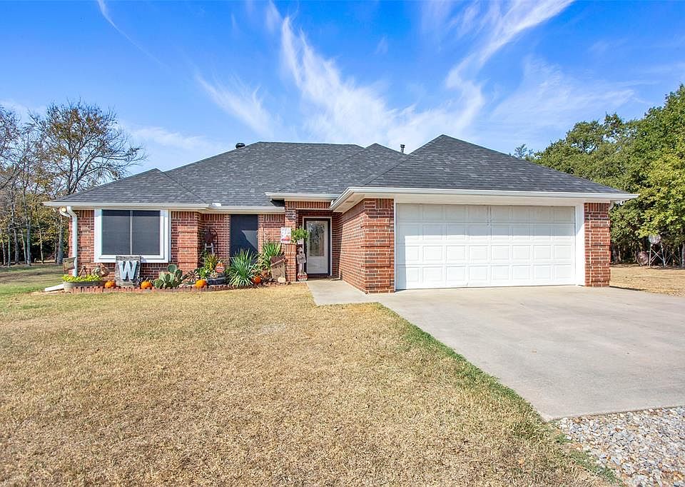 Ranch-style home featuring a garage and a front yard