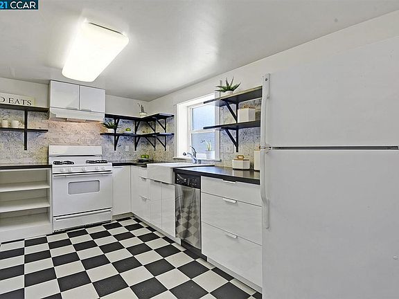 Kitchen with dishwasher, gas stove, and window to garden