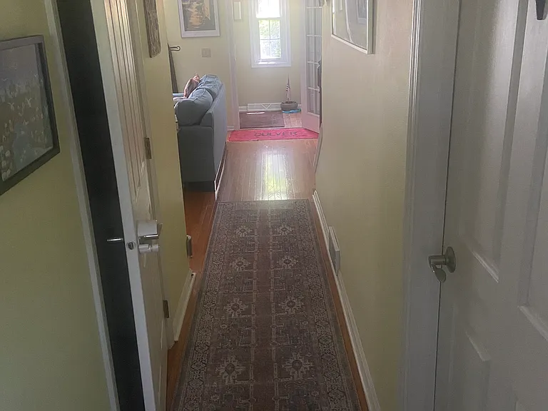 Hallway from kitchen to the front door. Door on right leads to basement, on left is the 1st fl bathroom