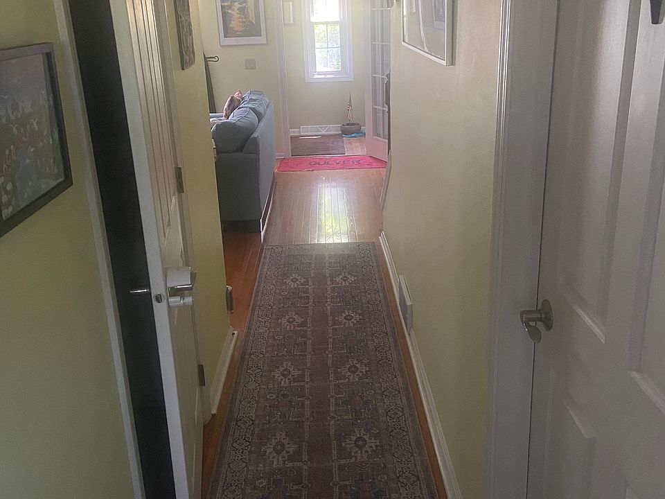 Hallway from kitchen to the front door. Door on right leads to basement, on left is the 1st fl bathroom