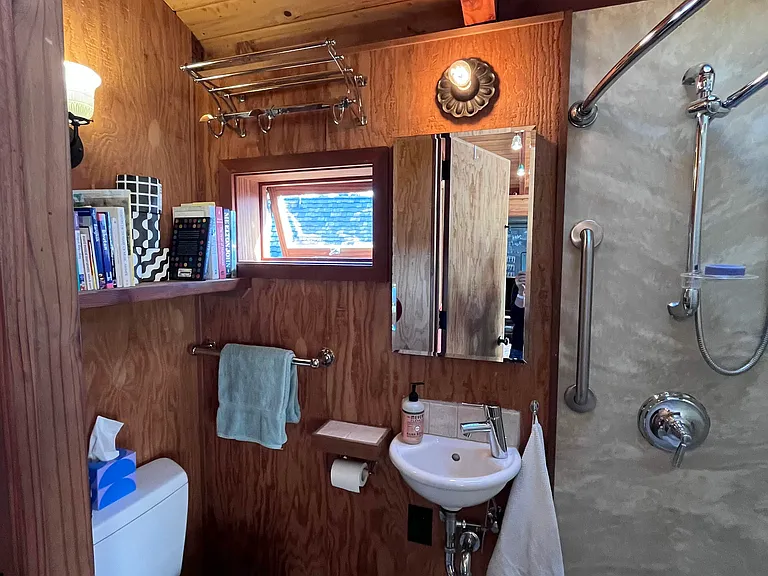 WC with overhead shelves, window, skylight, dual lights and ventilation; tile flooring
