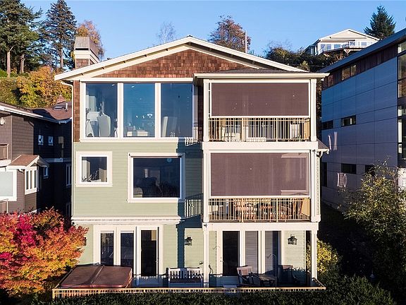 Back view of the home featuring 2 covered view decks and large patio with Hot Tub.