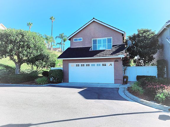 Garage Entry on Carrack cul-de-sac with Side Yard Gate to right, and fenced trash area to left.