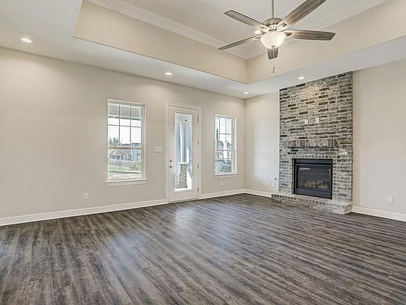 LIVING AREA WITH FIREPLACE WITH FLOOR TO CEILING BRICK SURROUND AND ACCESS TO THE COVERED PATIO.