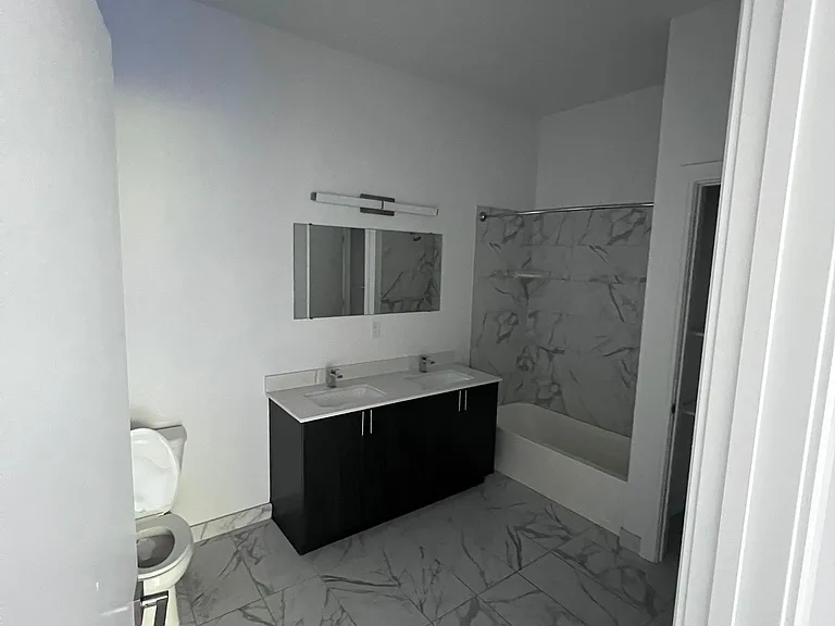bathroom with double sink and closet