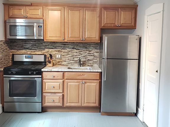 Kitchen with stainless steel appliances, granite countertop and large pantry closet for additional storage.