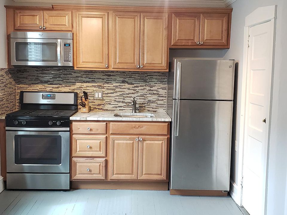 Kitchen with stainless steel appliances, granite countertop and large pantry closet for additional storage.