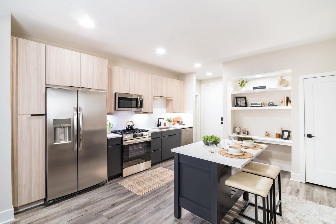 A light-filled kitchen with an oversized island, open shelving, and clean-lined finishes that support everyday cooking and casual dining.