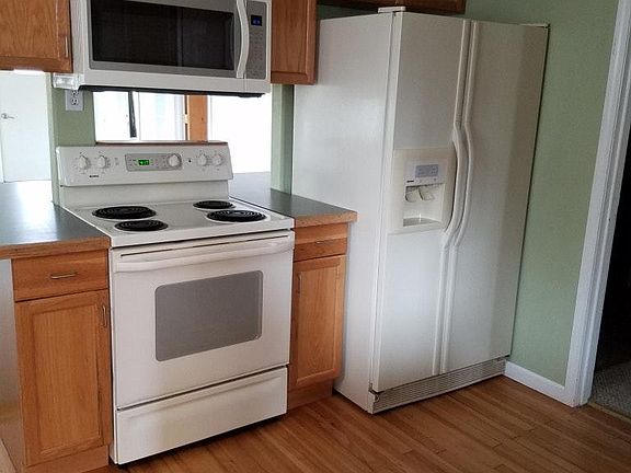 kitchen showing range with overhead microwave, and fridge wi