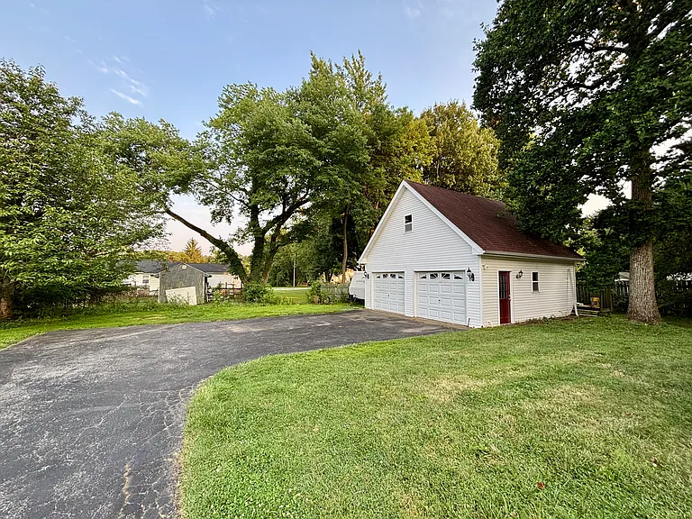 Oversized detached two-car garage with abundant storage space, a long paved driveway, and plenty of room for vehicles, hobbies, or a workshop.