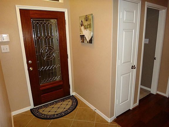 View of front door & entry. To the left of front door are two bedrooms and full bath.
